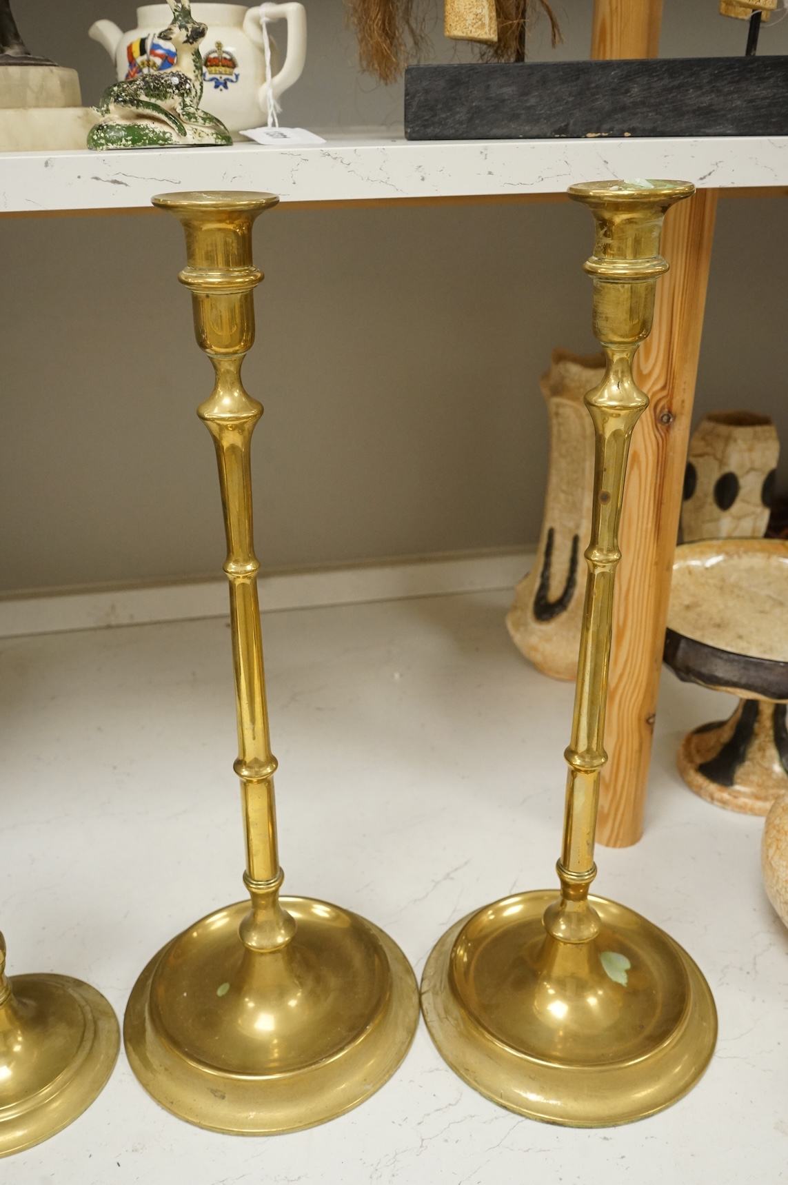 Two pairs of brass candlesticks to include a pair of figural examples, largest 47cm high
